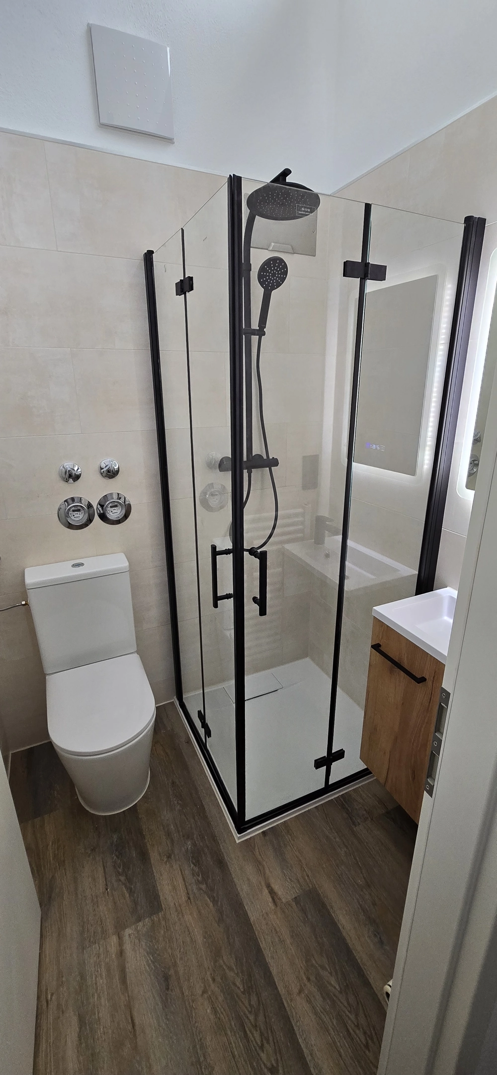 Kompakte Badsanierung mit moderner Eckdusche in schwarzem Glasrahmen, Regendusche, Toilette und Waschtischunterschrank
