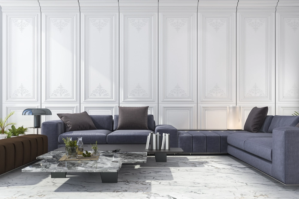 Wohnzimmer mit eleganten Stuckarbeiten an weißen Wandpanelen, grauer Sofalandschaft und Marmorboden