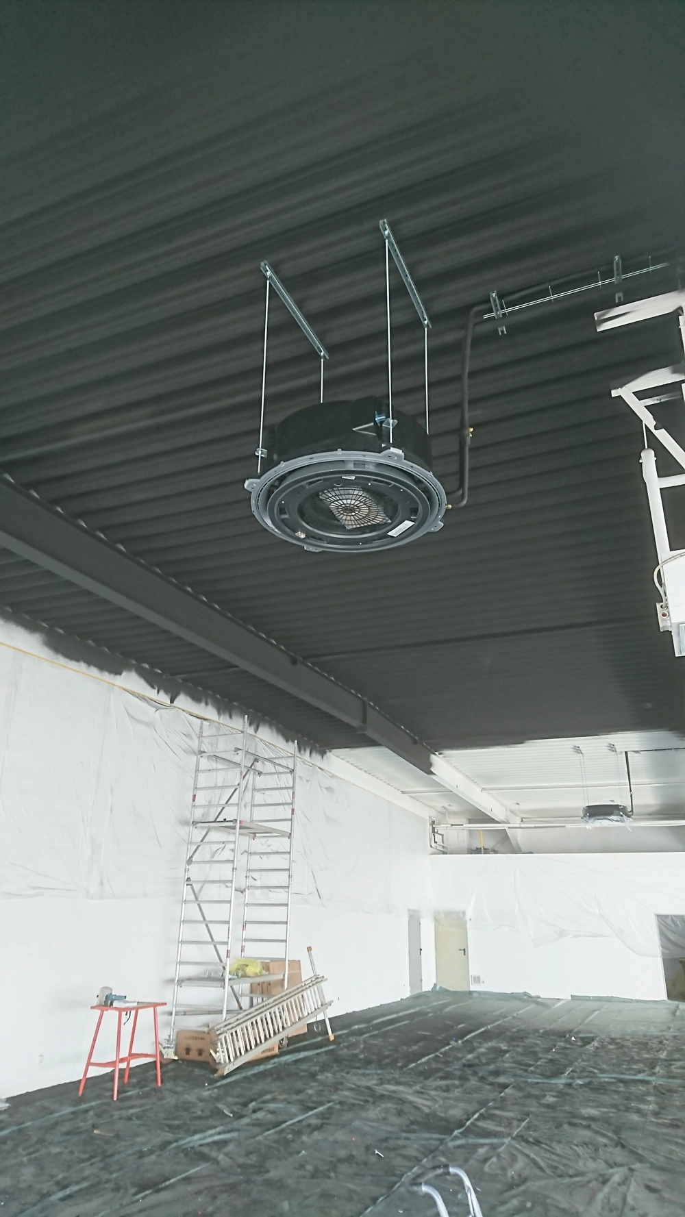 Abgehängte Decken mit installierter Lüftungsanlage, Baustellengerüst und Leiter im Innenausbau