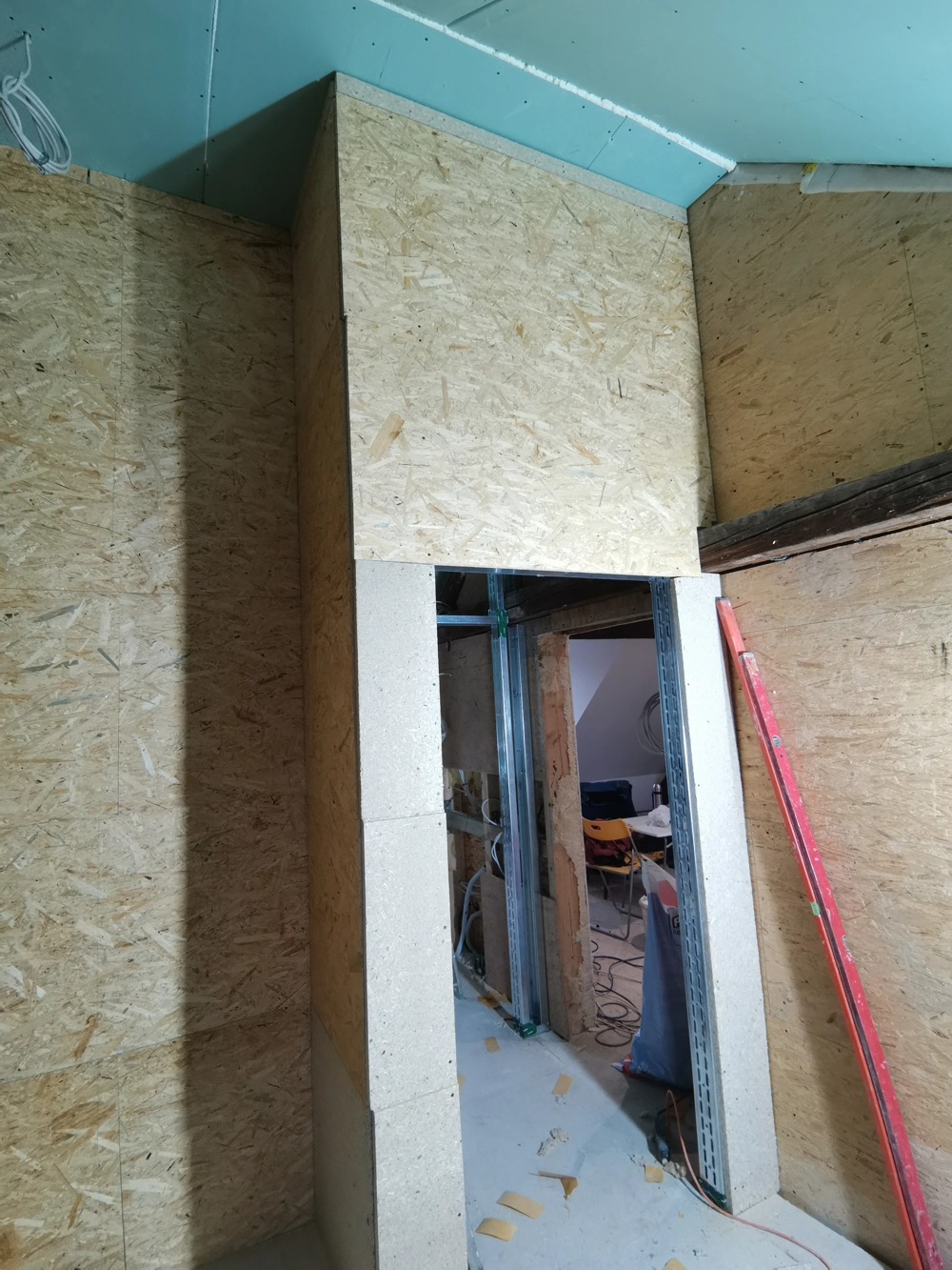 Trockenbauwand mit OSB-Platten und Montageschiene um Türöffnung auf Baustelle im Dachgeschossausbau