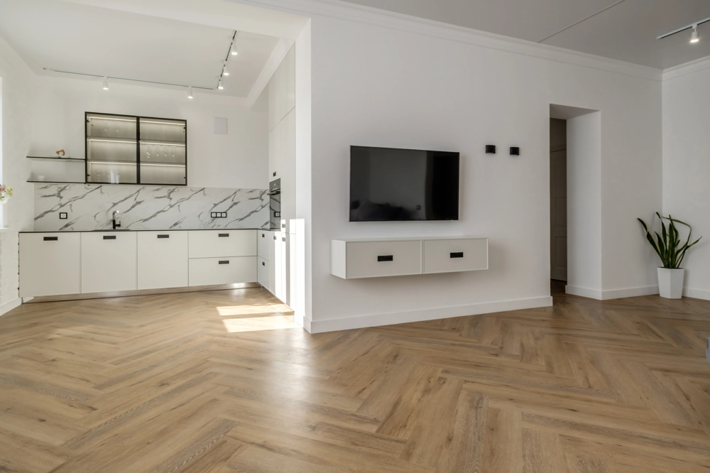Renoviertes offenes Wohnküche mit Marmorrückwand, weißer Küchenzeile und Herringbone-Parkett (Bodenverlegung)