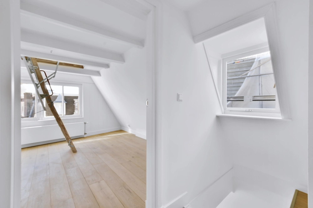 Renovierter Spitzboden mit hellen Wänden, Eichenboden und ausfahrbarer Bodentreppe – Dachgeschossausbau