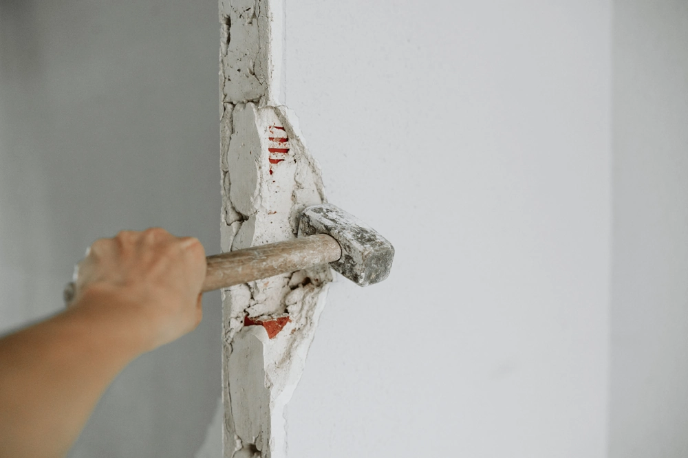 Vorschlaghammer, der bei Abbrucharbeiten eine Innenwand aufbricht